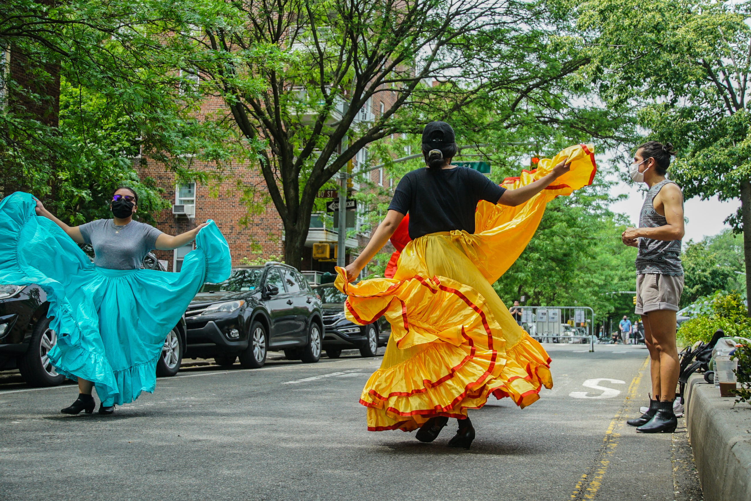 Rehearsing on 34th Avenue, dancers swirl their skirts as they practice movements.